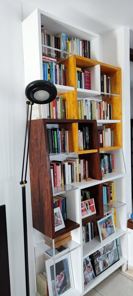 Piccolo angolo lettura con libreria artigianale e poltrona