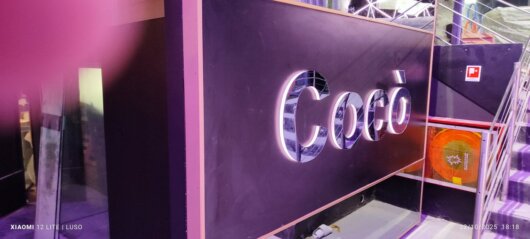 Insegna luminosa artigianale con luce calda su facciata di negozio