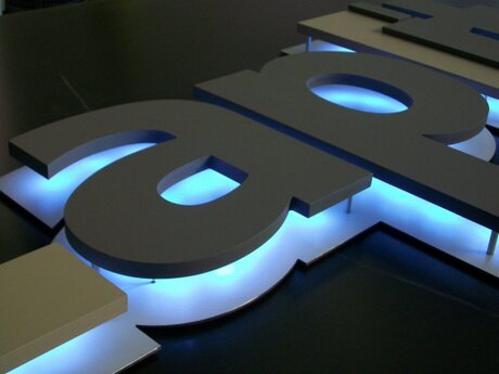 Lampada-insegna artigianale con logo minimal